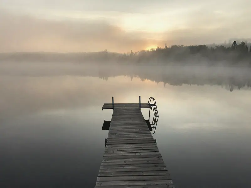 A dock running out into fog at first light